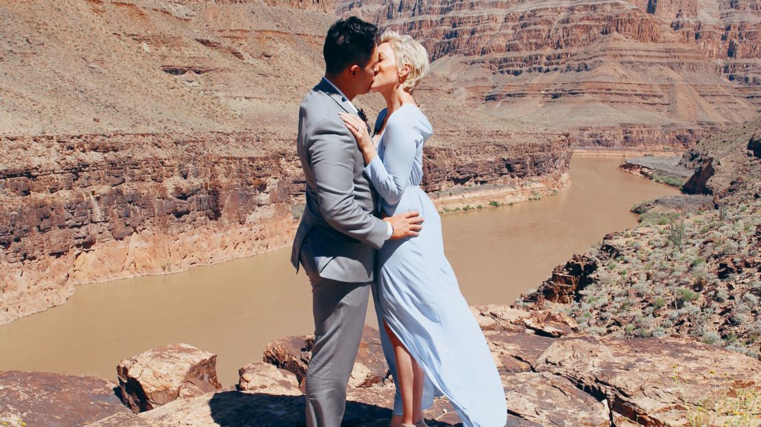 Bride and groom kissing after vows in front of Colorado River in Grand Canyon. 