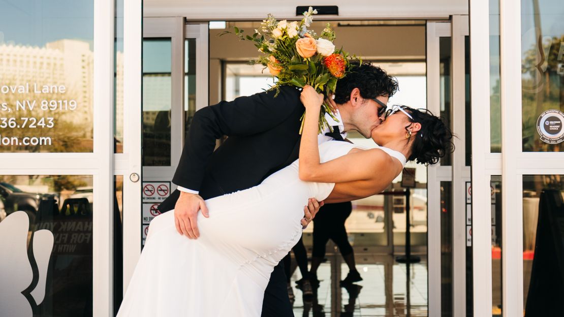 a soon-to-be married couple poses outside of the air terminal before a Las Vegas helicopter tour