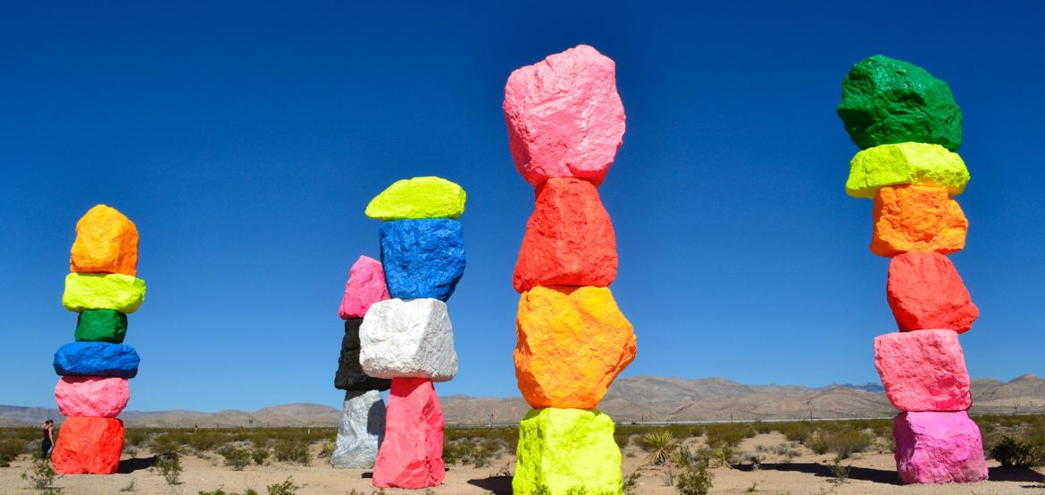 Seven rainbow-colored boulders forming rock towers, standing over 30 feet tall