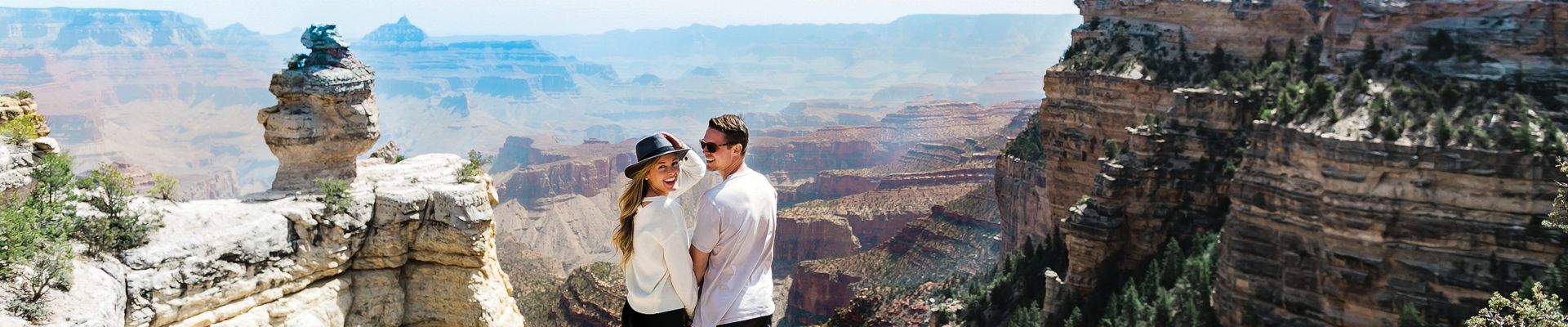 a couple stands at a lookout point during a Grand Canyon day trip from Las Vegas