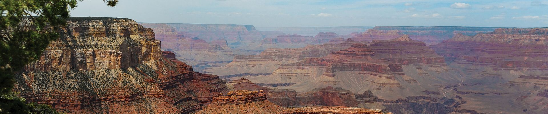 A Grand Canyon South Rim helicopter tour with partially cloudly views of the red canyon walls