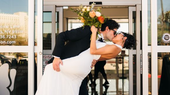 a soon-to-be married couple poses outside of the air terminal before a Las Vegas helicopter tour