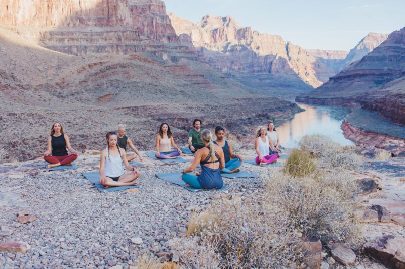 Several Grand Canyon visitors practice yoga at the bottom of the West Rim