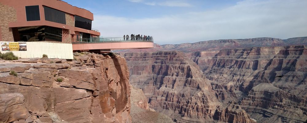 Guests at the Grand Canyon West stand over the canyon's edge atop the Skywalk Bridge