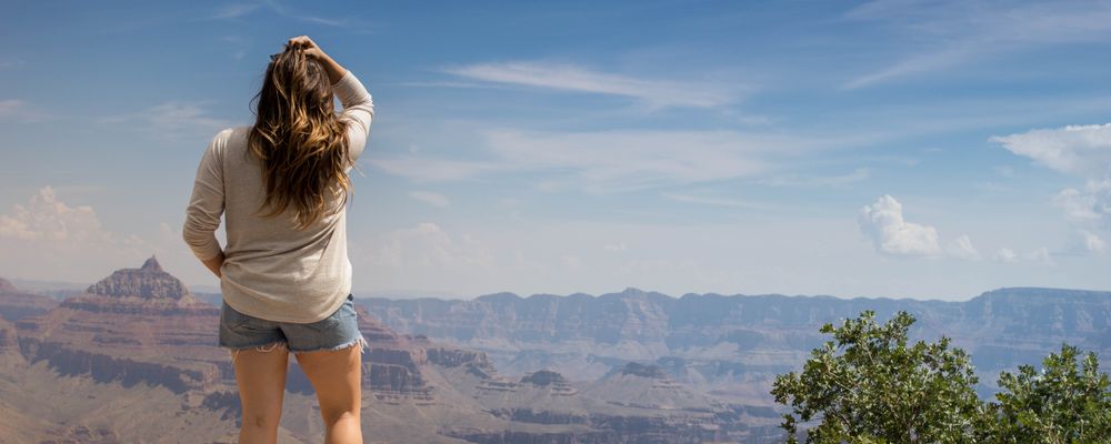 A woman stands at the edge of a scenic Grand Canyon National Park lookout point
