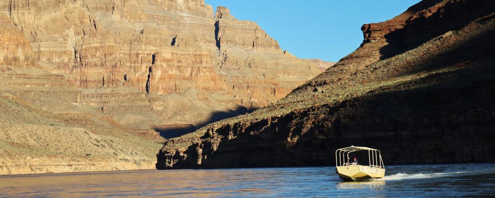 a colorado river boat tour takes place between the grand canyon walls