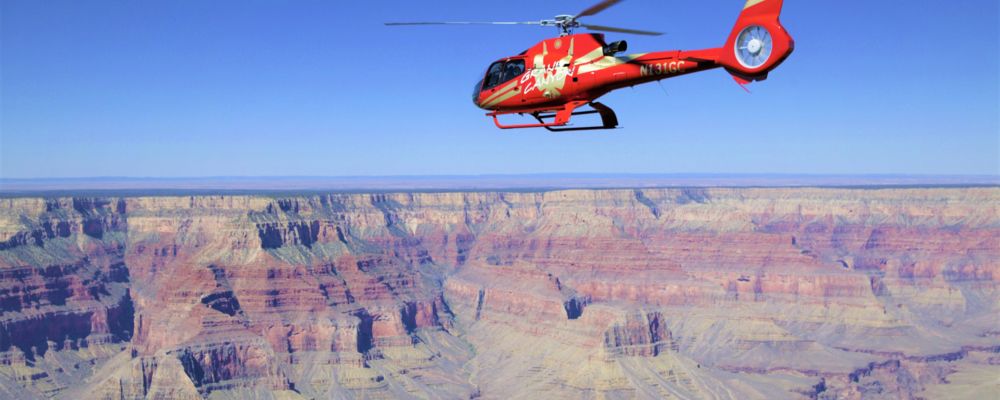 A helicopter flying over Grand Canyon during aerial tour.