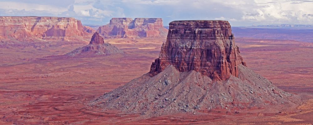 Tower Butte with the colorful desert landscapes behind it.
