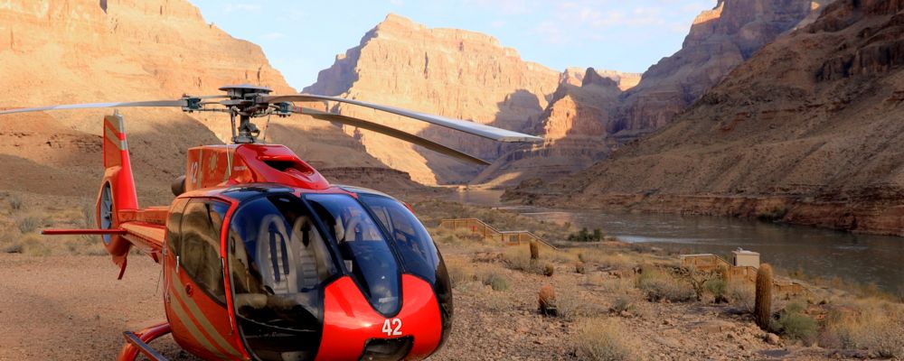A helicopter sitting at the bottom of the Grand Canyon.