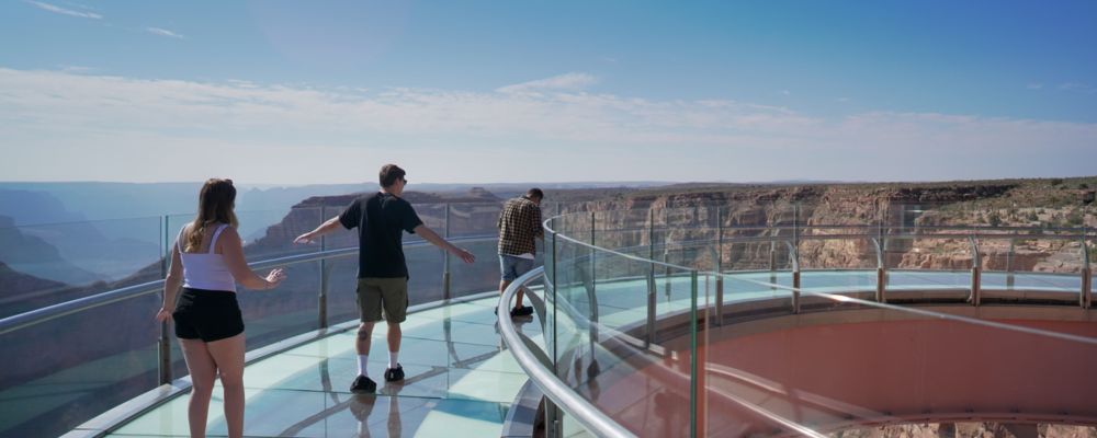 Guests are walking along the glass Skywalk Bridge at Grand Canyon West.