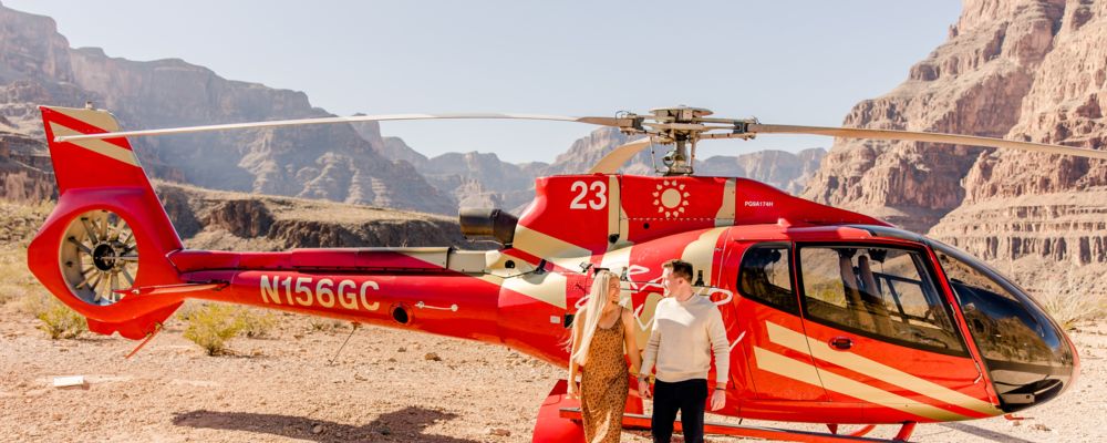 A couple exited a red helicopter after landing on the floor of the Grand Canyon.