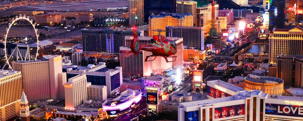 A Las Vegas helicopter tour flies over the Strip casinos at dusk