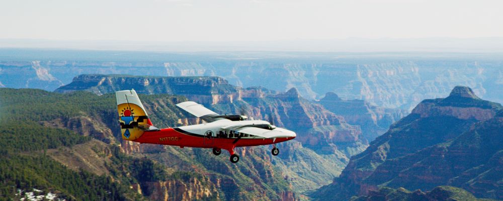 a sightseeing airplane flies over the grand canyon south rim
