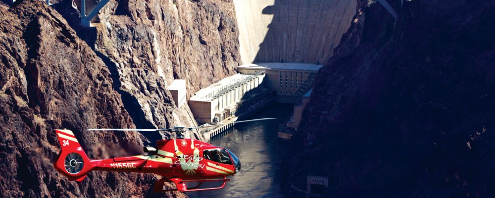 a sightseeing helicopter flies from Las Vegas over Hoover Dam