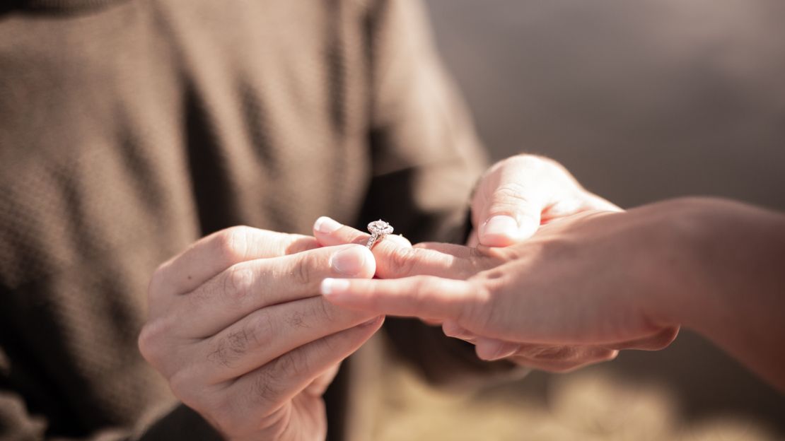 Man putting engagement ring on woman at Grand Canyon. 