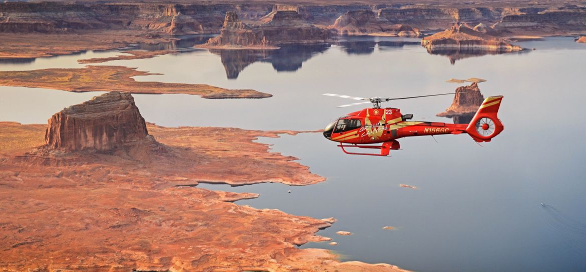 a Page Arizona helicopter flies over Lake Powell and the surrounding desert landscape