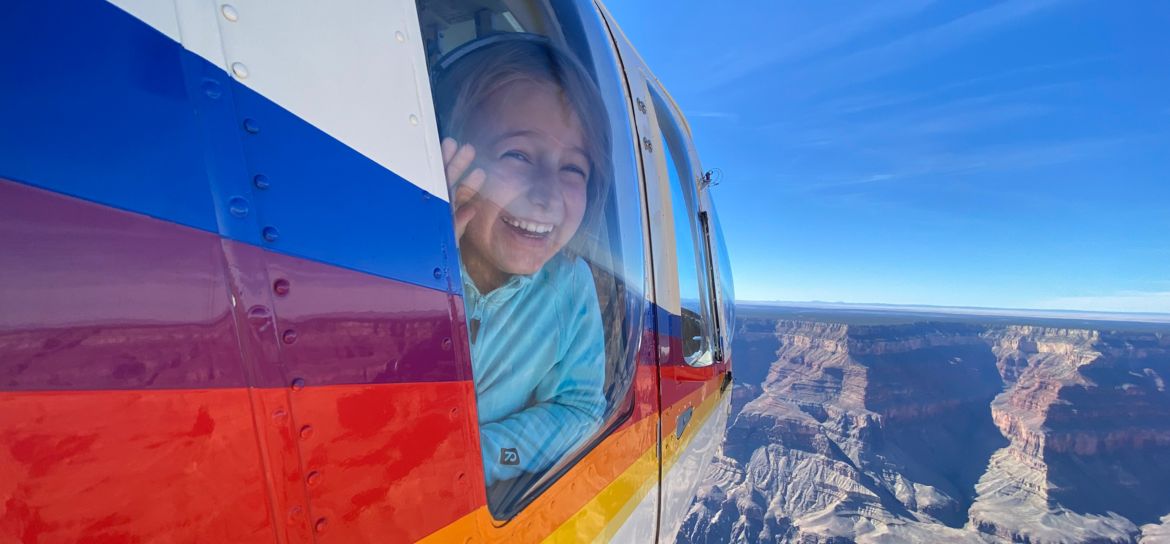 a child looks excitedly out the window of a Grand Canyon helicopter tour