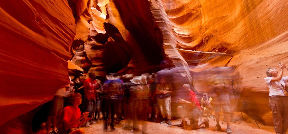 a long exposure shot of visitors wandering the sandstone corridors within Antelope Canyon