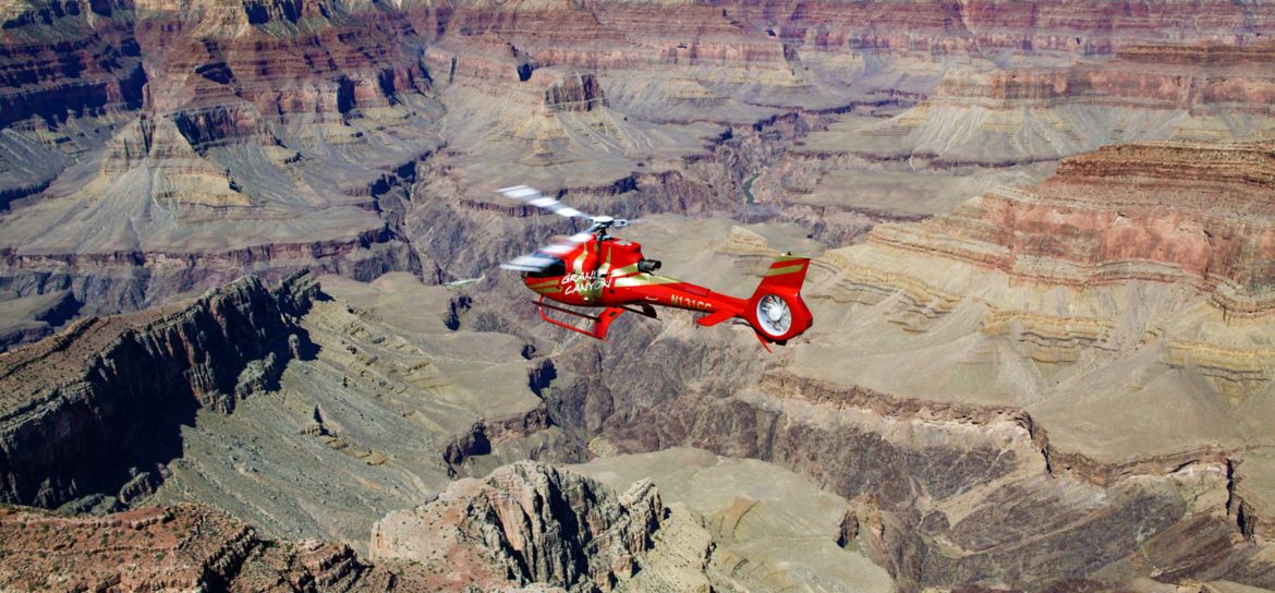 a helicopter tour flies over a massive gorge within the Grand Canyon National Park
