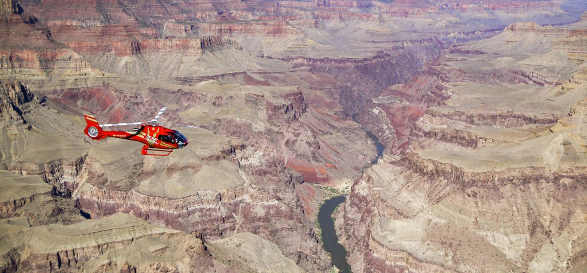 a helicopter tour flies over a massive gorge within the Grand Canyon National Park