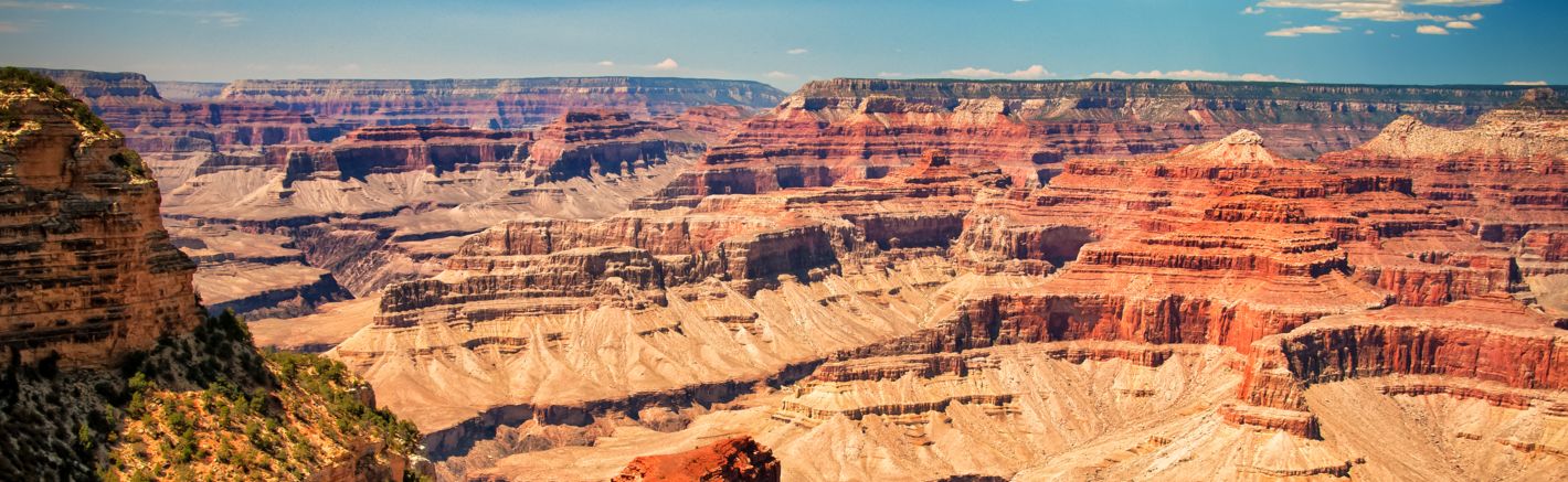 the bright orange and red walls of the Grand Canyon seen on a sunny day