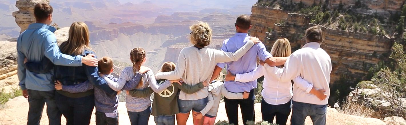 a large family hugs at a Grand Canyon National Park lookout point
