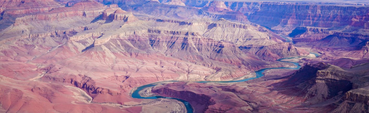 a broad view of the Grand Canyon walls and the blue Colorado River winding between them