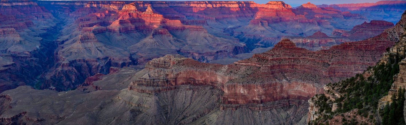 a Grand Canyon National Park viewpoint seen at sunset amidst a purple sky