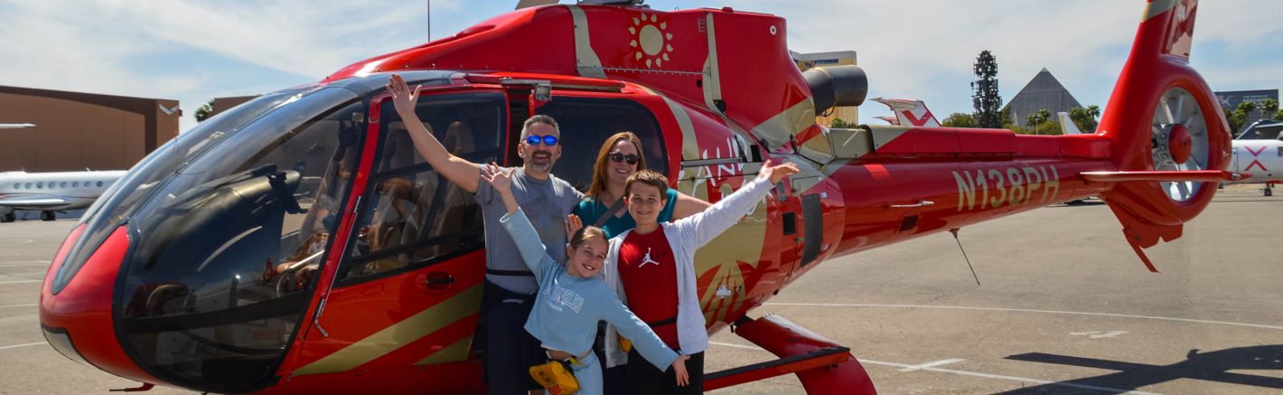 a family poses at the Las Vegas air terminal in front of a helicopter