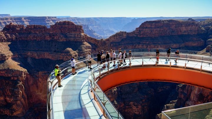 RS20111_people-taking-in-the-views-on-skywalk-bridge-at-grand-canyon-west-with-eagle-point-in-distance-clear-skies