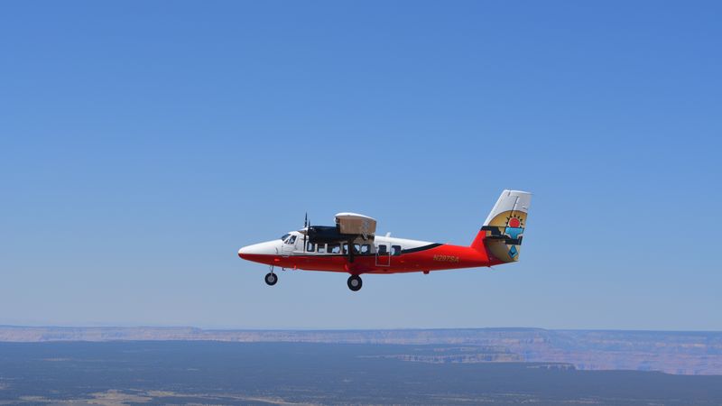 A Twin Otter plane flying over Grand Canyon South Rim