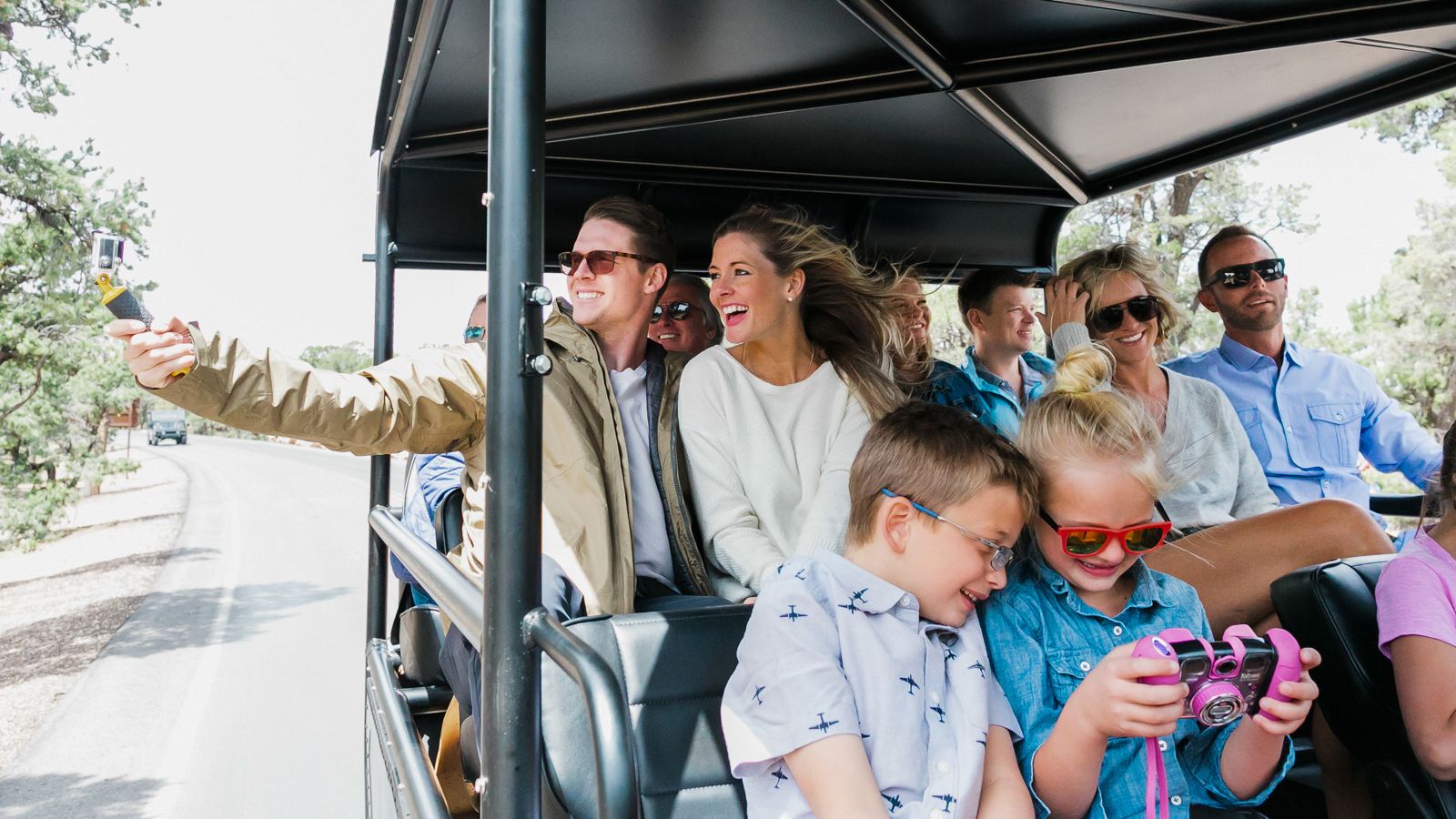 a group of happy passengers ride inside a military-style Hummer at the Grand Canyon