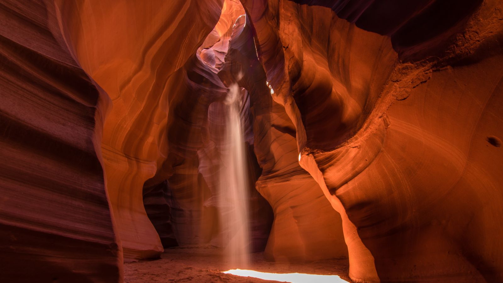 light shafts beam down from the surface of Antelope Canyon