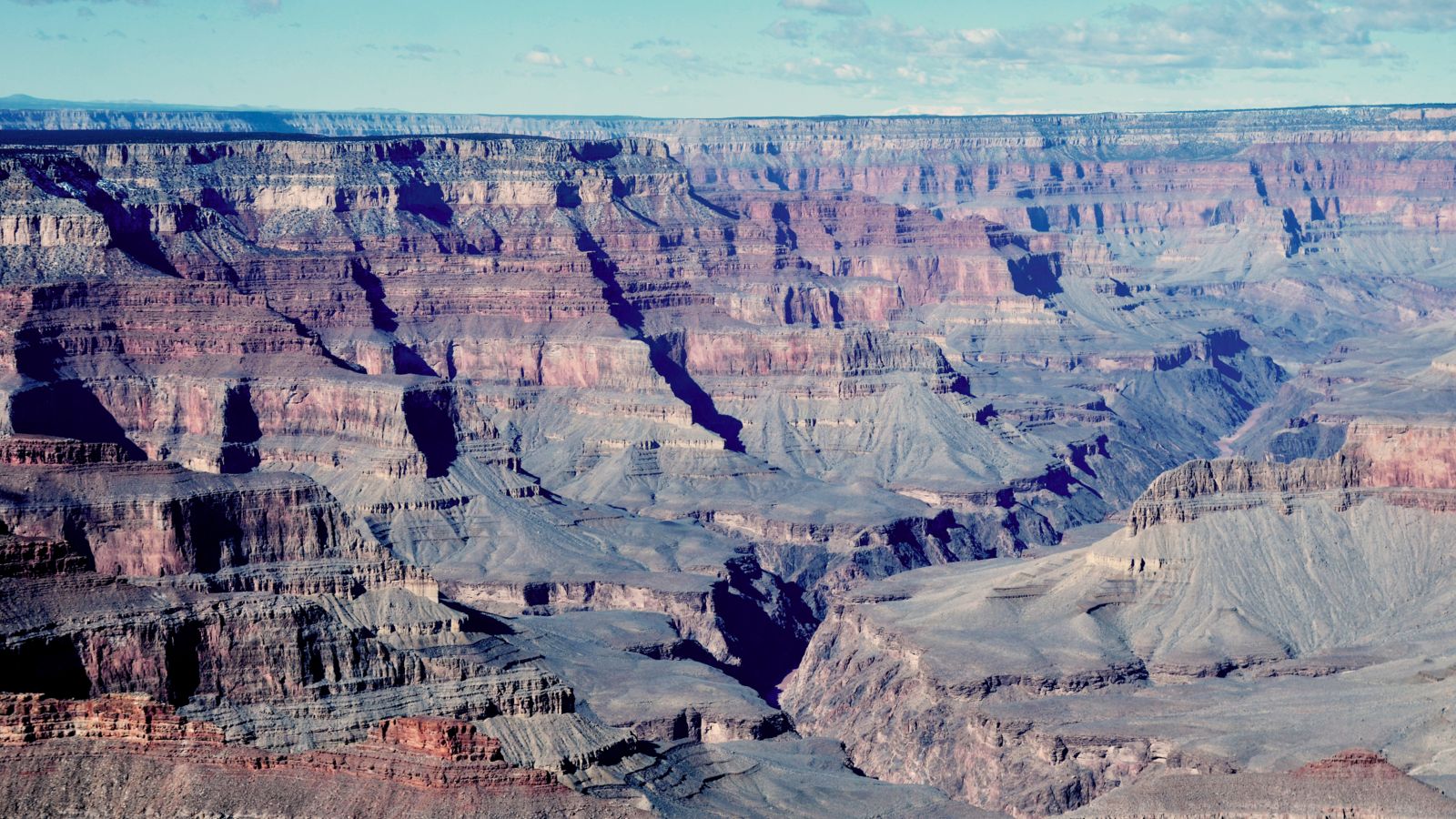 A panoramic view of the Grand Canyon South Rim on a bright and hazy day.