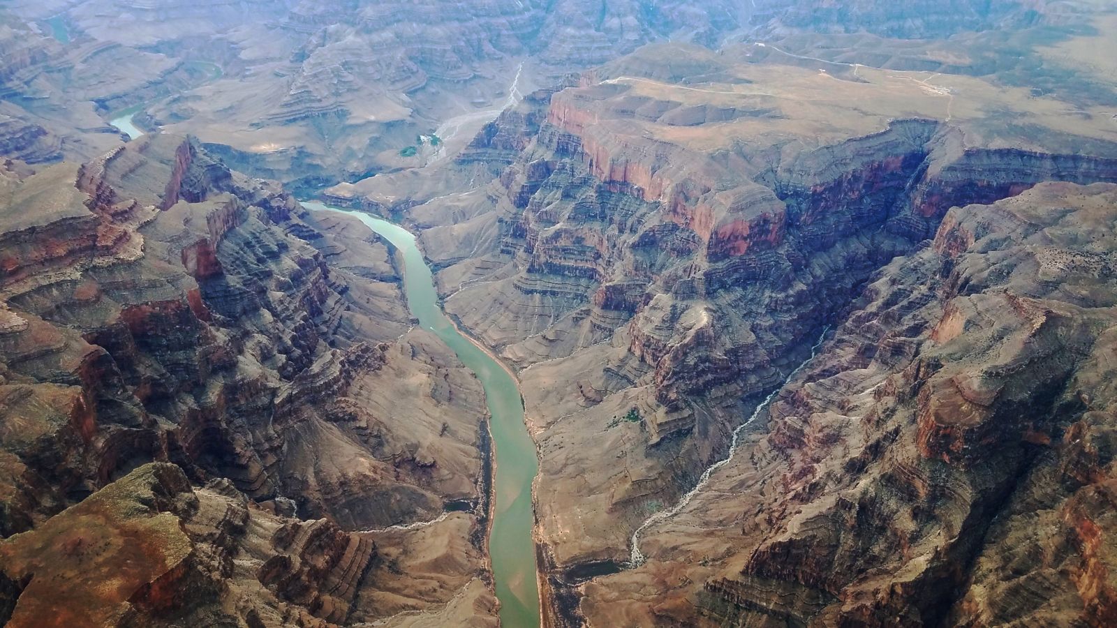 the blue waters of the colorado river with grand canyon walls on either side, seen from above