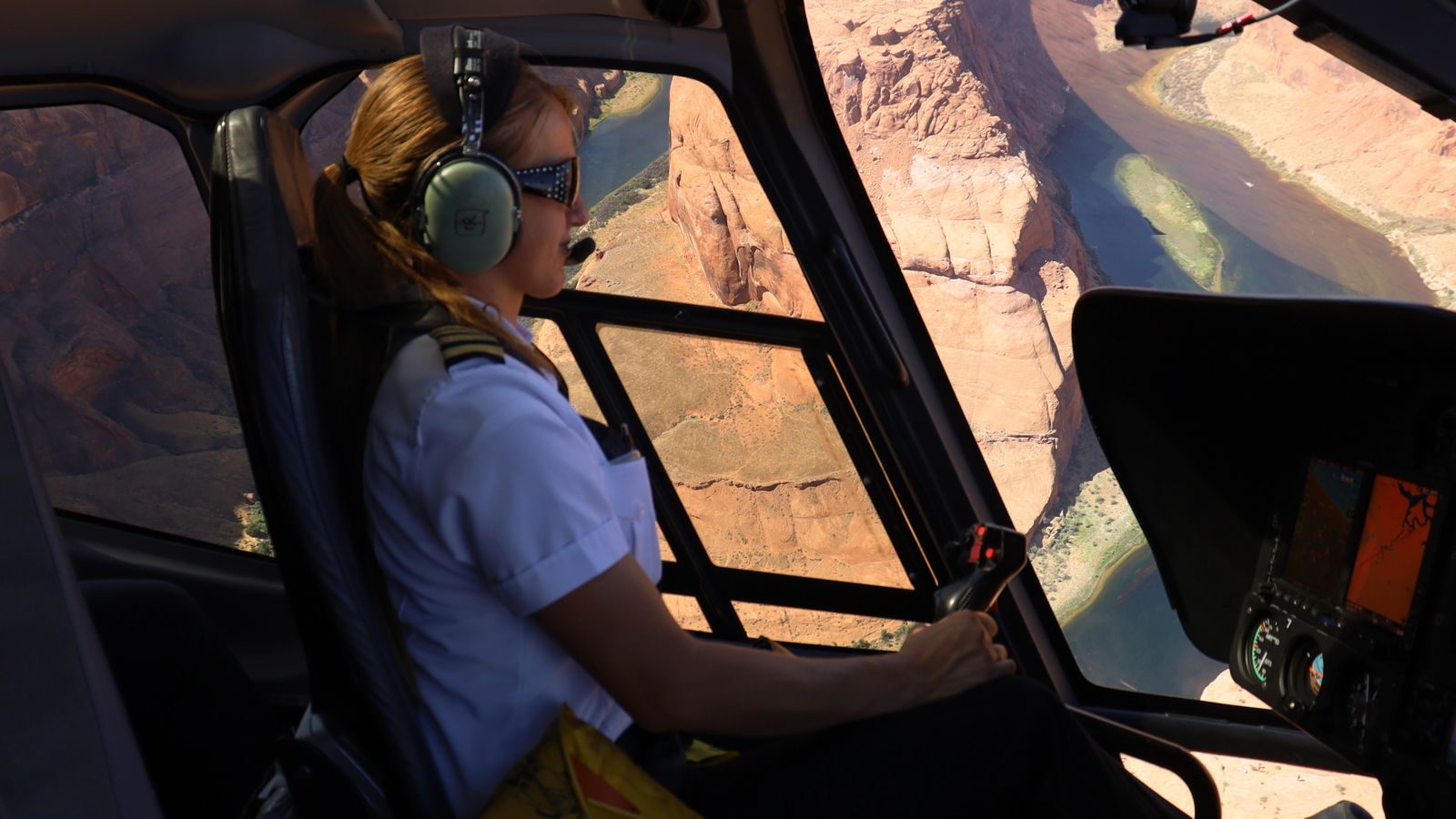 a pilot flies a helicopter tour over horseshoe bend in page arizona