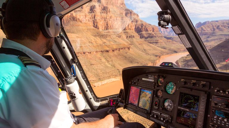 Pilot flying a helicopter through Grand Canyon West Rim