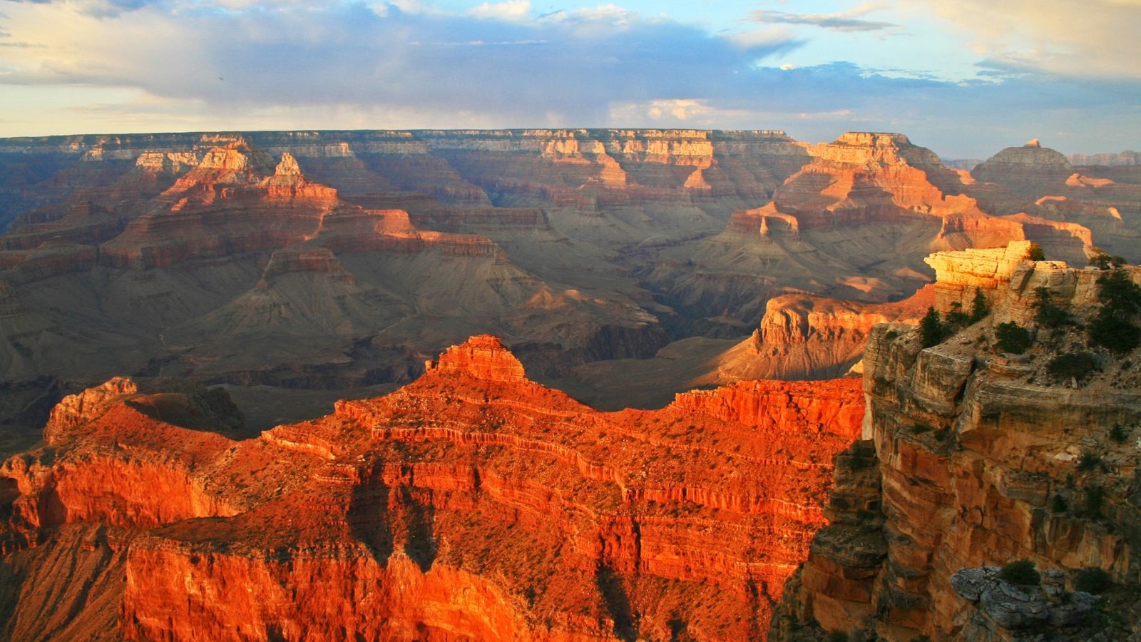 a south rim rock formation lit up bright orange by the sunset