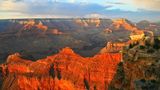 a south rim rock formation lit up bright orange by the sunset