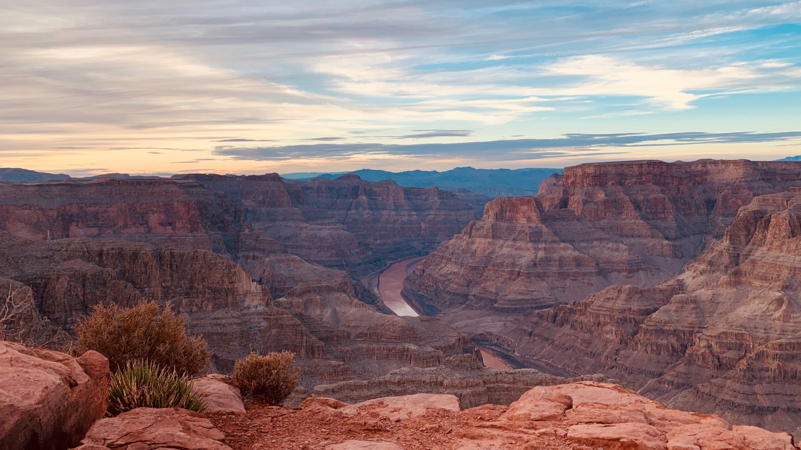 pink and red sandstone walls of the Grand Canyon West seen during an airplane tour at sunset