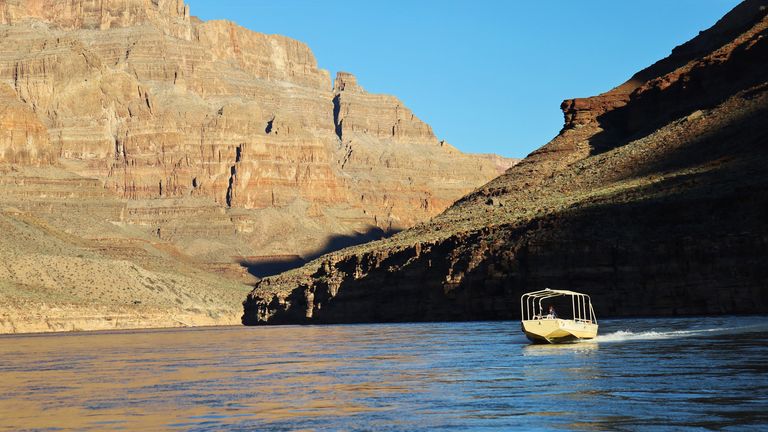 Hualapai River Runners pontoon boats float along the Colorado River at the bottom of the Grand Canyon West Rim