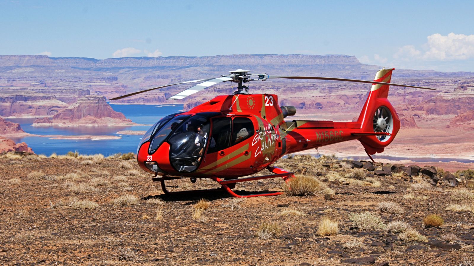 Red helicopter on the top of Tower Butte with Lake Powell in the background.