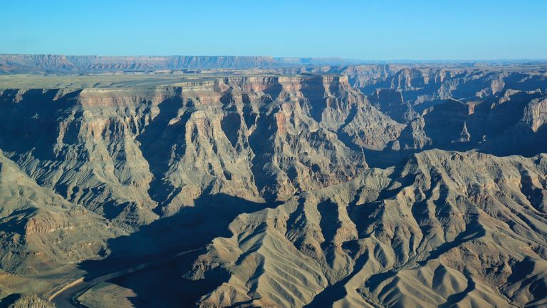 the rippling rock walls of the Grand Canyon West Rim seen from the sky