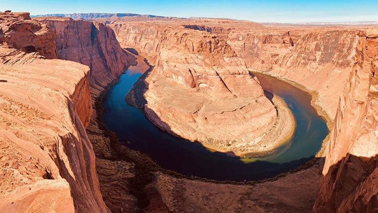 a stunning panoramic view of Horseshoe Bend and the deep blue waters of the Colorado River