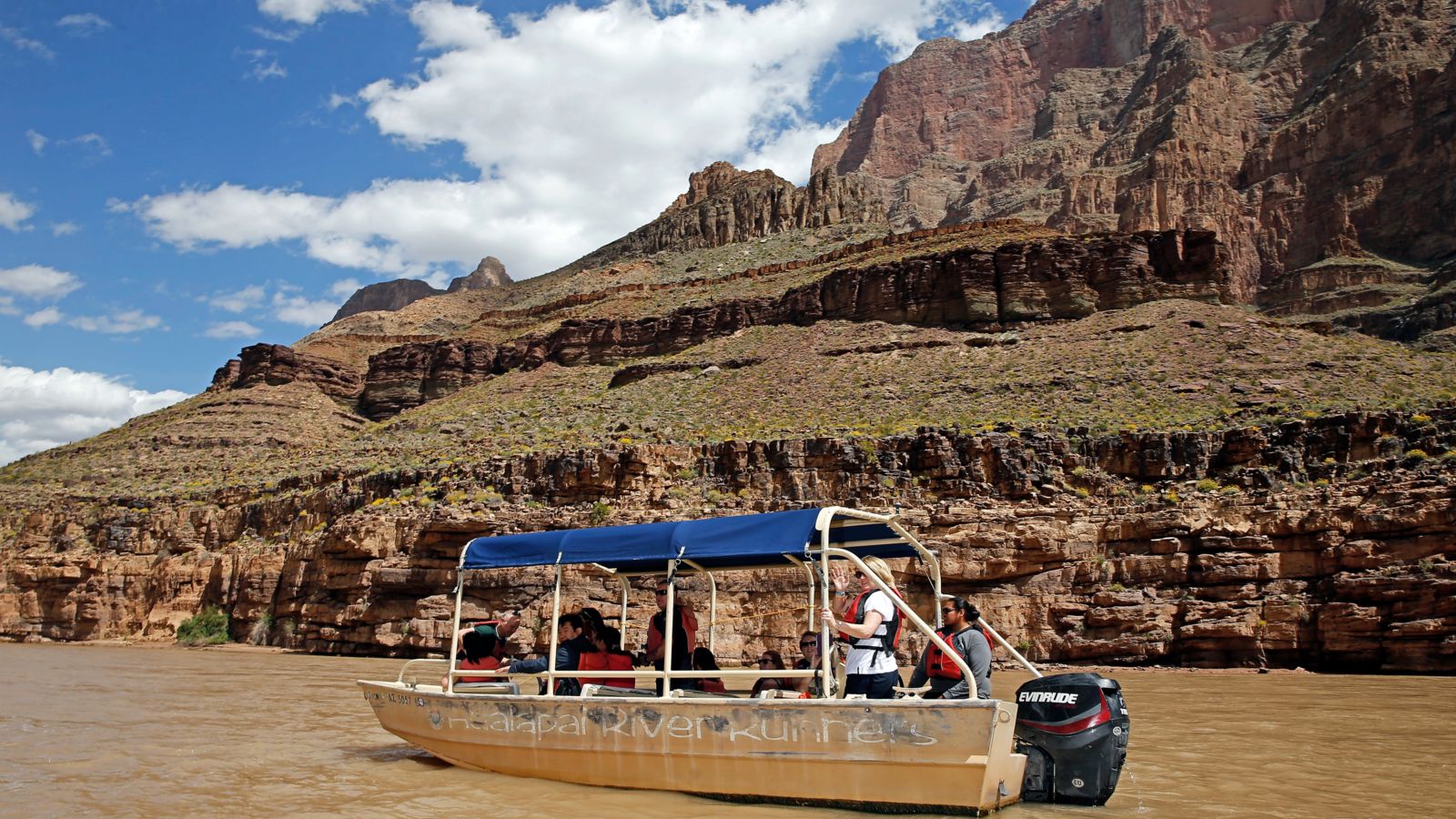 A boat pilot navigates a boat of guests up the mighty Colorado on a short cruise through the Grand Canyon West Rim