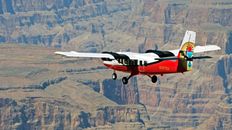 A Twin Otter airplane flying over the Grand Canyon.