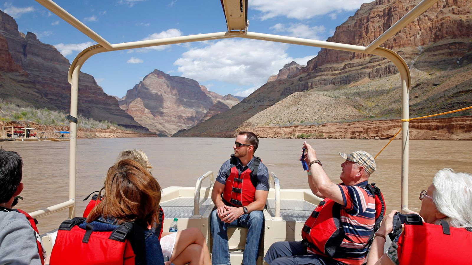 Passengers on a pontoon boat on the Colorado River enjoying the views of the canyon walls at Grand Canyon West Rim