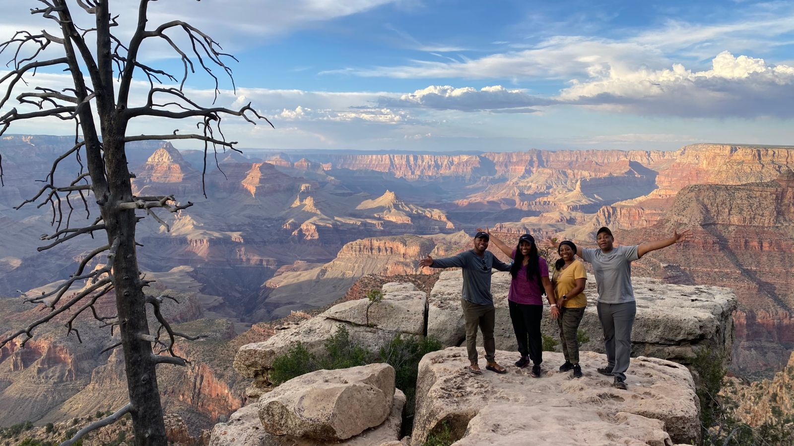 A happy family stands at the edge of the Grand Canyon during a Hummer excursion