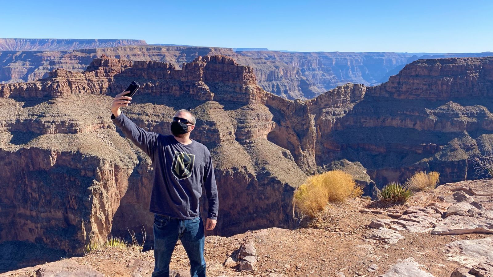 a visitor on a Grand Canyon tour takes a selfie in front of Eagle Point at the West Rim