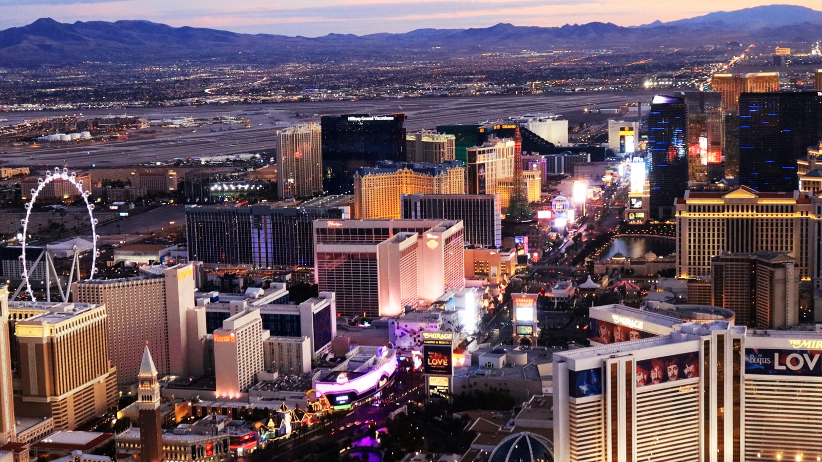 the las vegas strip seen at sunset with a helicopter tour taking place
